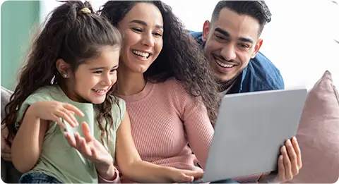 Happy family using high-speed internet at home — smiling parents and child enjoying time together on a laptop.