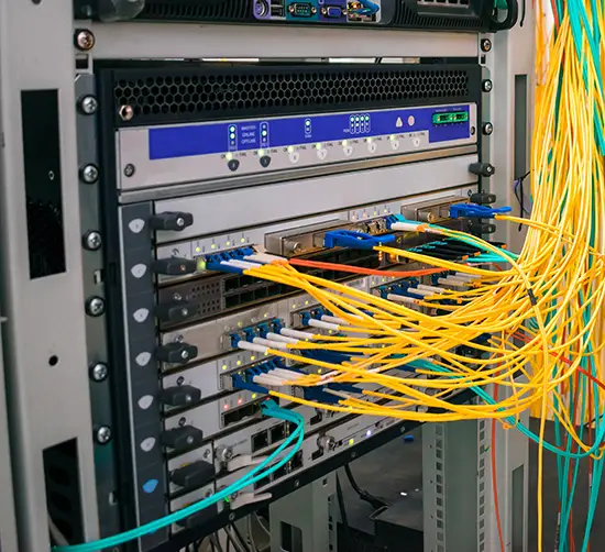 Close-up of a data center rack with fiber optic patch panels and network equipment, showcasing high-speed fiber infrastructure.